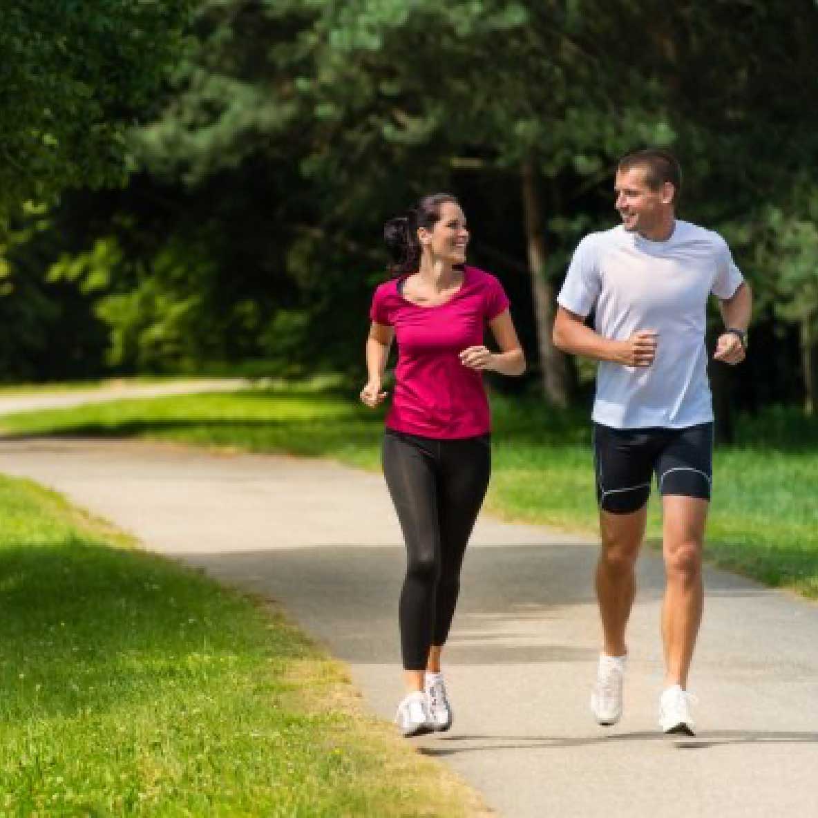 Cheerful couple friends running in park